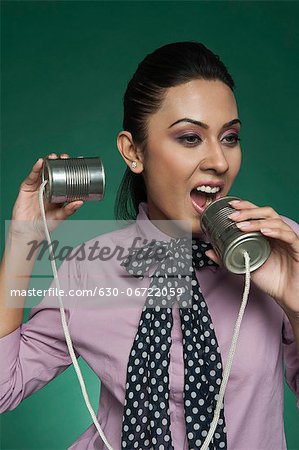 Businesswoman using a tin can phone