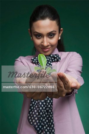 Businesswoman holding a seedling