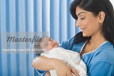 Woman carrying her baby and smiling