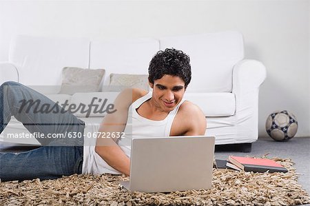 Man using a laptop on the floor