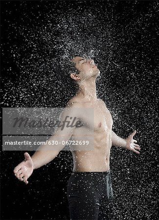 Bare chested man splashed with water