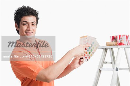 Man choosing paint from color swatches for his house