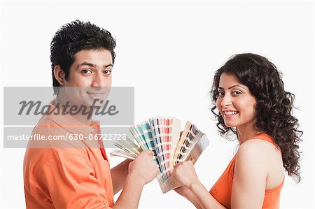 Couple choosing color from color swatches for their house