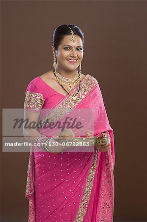 Portrait of a woman in sari holding religious offering