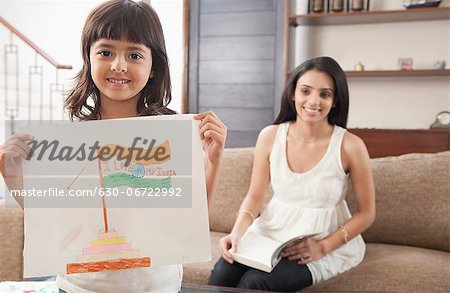 Woman looking at her daughter showing drawing of Indian flag