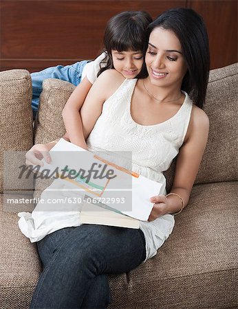 Girl showing drawing of Indian flag to her mother