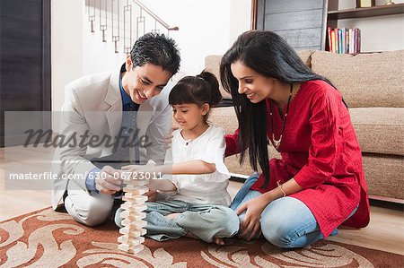 Girl playing Jenga with her parents