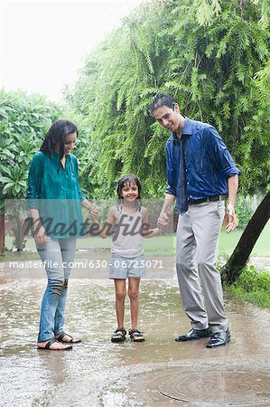 Family enjoying in rain in a park