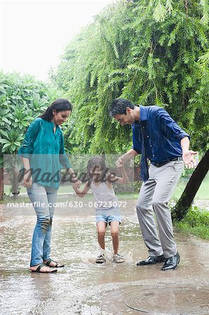 Family enjoying in rain in a park