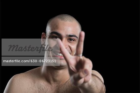 Portrait of a man making a peace sign