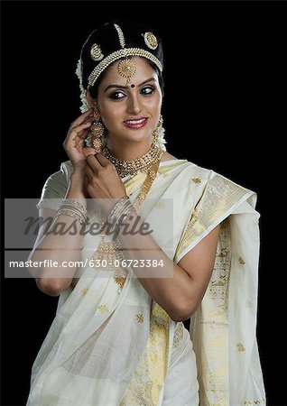 Indian woman in traditional clothing adjusting her earrings