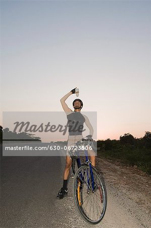 Cyclist pouring water over himself