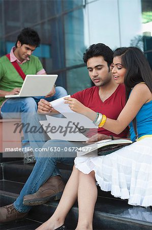 University students discussing on notes in university campus