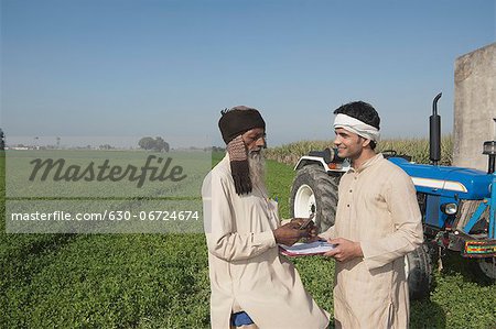 Farmer giving money to another farmer as agriculture loan, Sonipat, Haryana, India