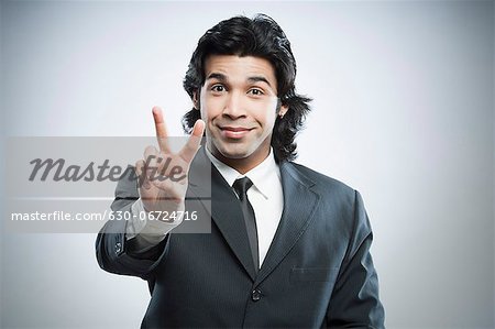Businessman showing victory sign
