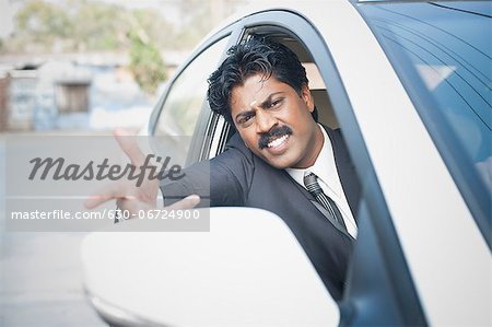 South Indian businessman driving the car and gesturing