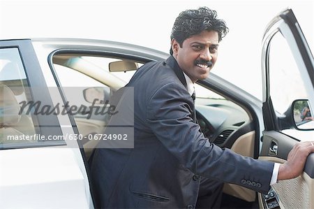 South Indian businessman coming out from the car