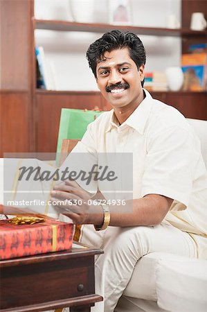 South Indian man smiling near gift boxes