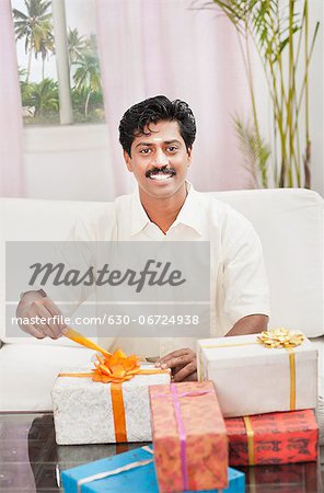 South Indian man smiling near gift boxes