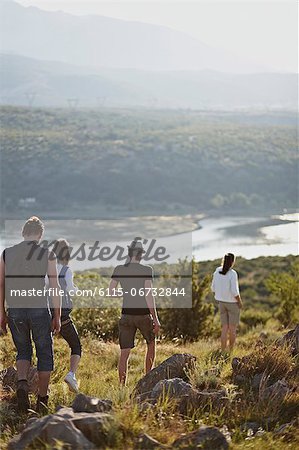 Croatia, Young people hiking round storage lake, rear view
