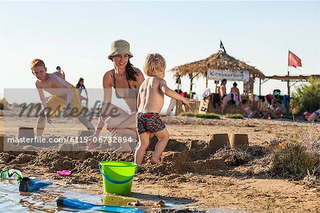 Croatia, Dalmatia, Mother With Sons On Beach, Background People