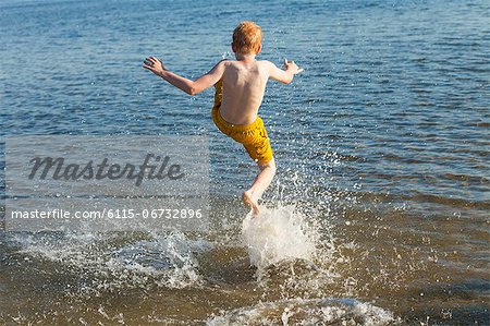 Croatia, Dalmatia, Boy Jumping In The Sea