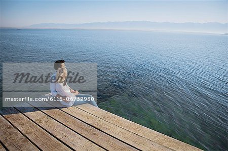 Croatia, Young couple sits on boardwalk, looking at view