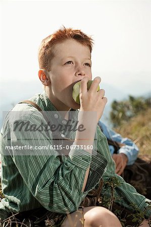 Germany, Bavaria, Boy in traditional clothing eating an apple