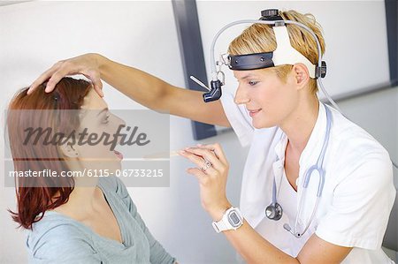ENT physician Examines the Throat of a Female Patient