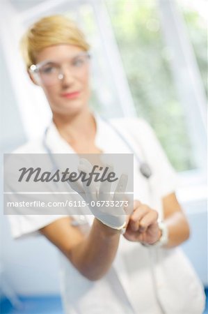 Female Doctor Putting On Surgical Gloves