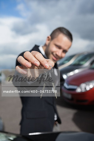 Happy businessman holding car keys outdoors