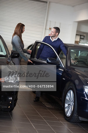 Businesswoman opening car door in a garage