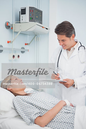 Doctor standing while holding a chart in hospital ward