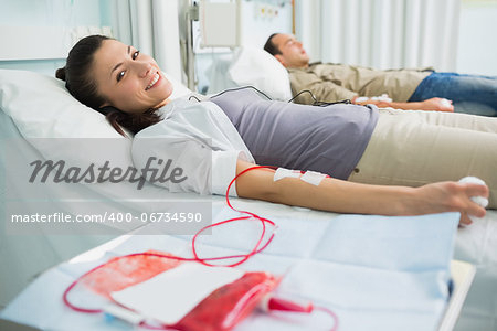 Smiling transfused patient next to another in hospital ward