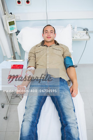 Male patient lying on a bed in hospital ward