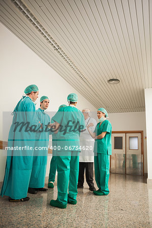 Surgery team speaking to each other in hospital hallway