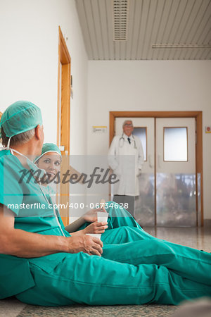 Surgeons talking next to a doctor in hospital