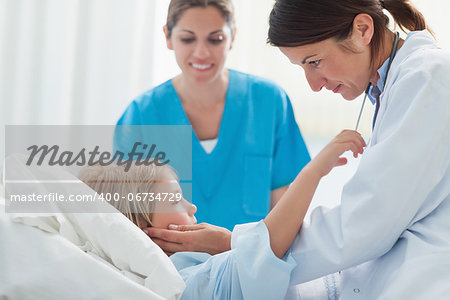 Doctor touching a child in hospital ward