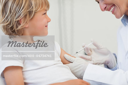 Doctor giving to a child an injection in examination room