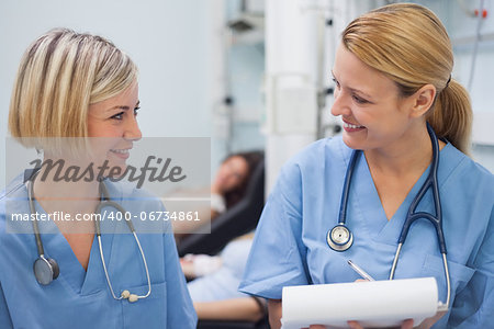 Smiling nurses talking in hospital ward