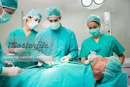 Surgical team performing on a patient belly in an operating theatre