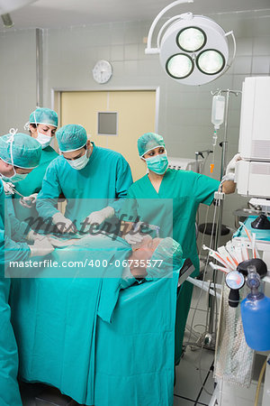 Nurse adjusting a monitor in an operating theatre