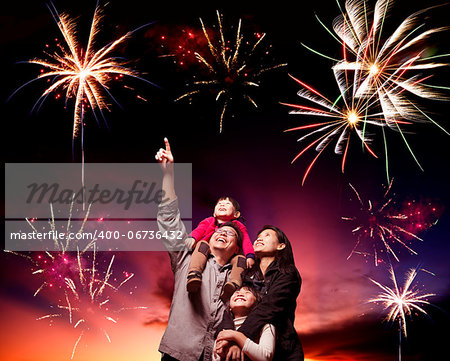 happy family looking fireworks in the evening sky