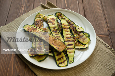 Grilled zucchinis cut to slices in a dish