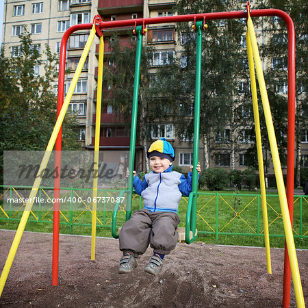 little boy teeter on playground at autumn