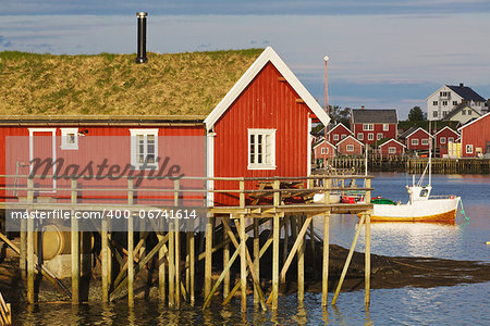 Typical red rorbu hut with turf roof in town of Reine on Lofoten islands in Norway