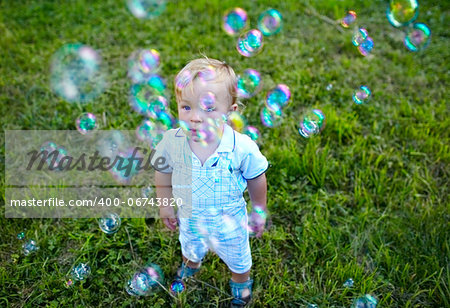 A little 16 month-old boy is looking at soap-bubbles. Baby's dreams.