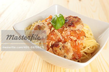 spaghetti with basil garnish and meatballs