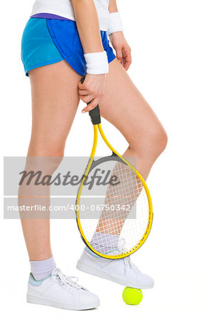 Closeup on female tennis player standing with one foot on ball