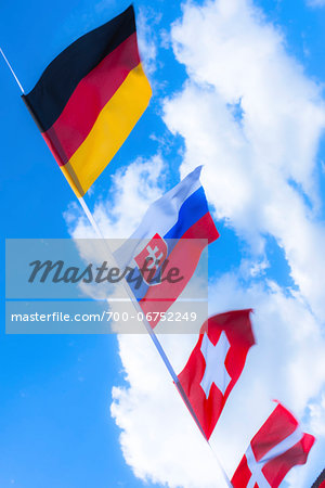 Swiss, German, Danish and Slovakian flags against blue summer sky